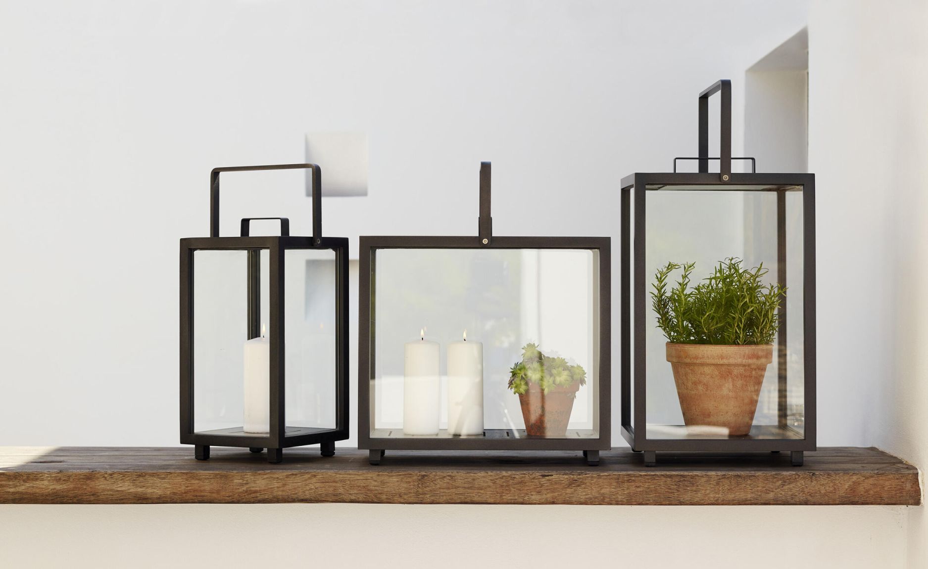 Rechteckige Lighthouse Laterne von Cane-Line aus Teakholz mit Kerzen und Pflanze im Innenraum.