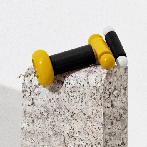 Alessi Korkenzieher ES17 mit gelben und schwarzen Akzenten auf einem Steinsockel. Design Korkenzieher.