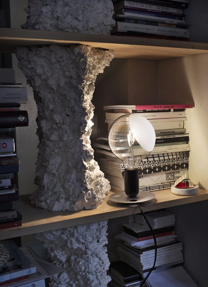 Grüne Lampadina LED Tischleuchte von Flos, ein Designstück auf einem Bücherregal, stimmungsvolle Beleuchtung.