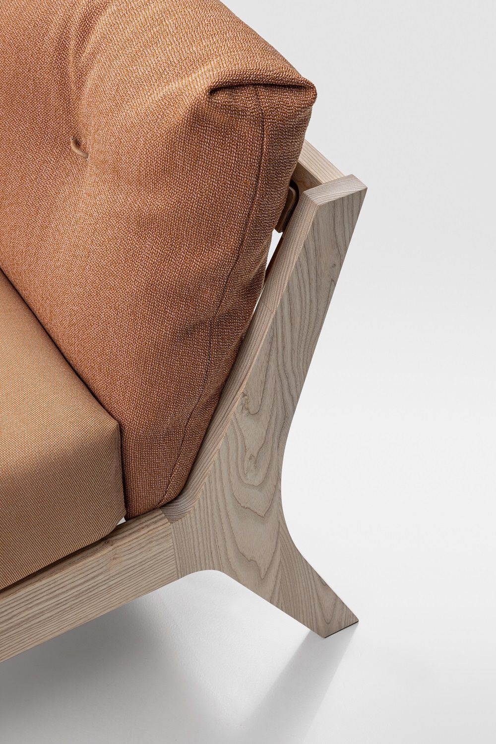 Detailaufnahme Mellow Bett: Massivholzrahmen mit orangefarbenem Kissen, modernes Design Schlafzimmermöbel.