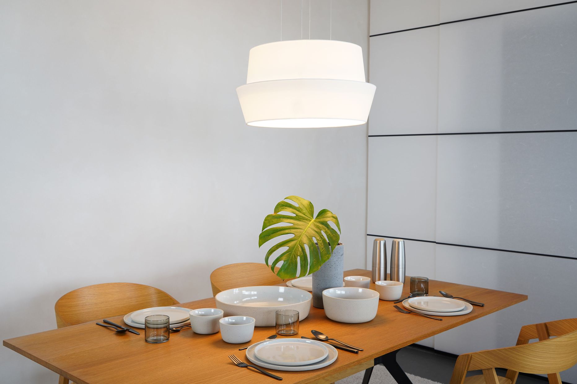 Helle Fly Pendelleuchte O von Maigrau über Esstisch mit Geschirr und Dekoration.