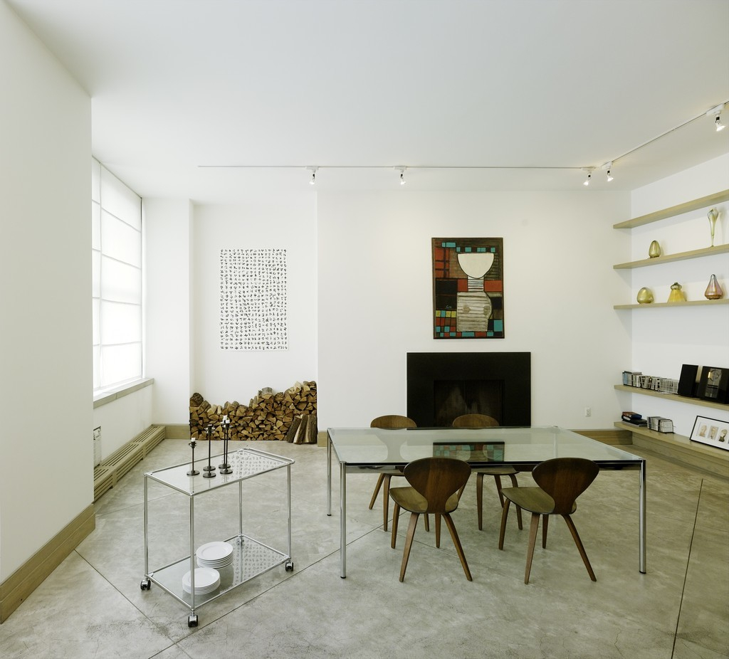 USM Haller Glastisch 175 x 100 cm im modernen Wohnzimmer mit Stühlen und Kamin.