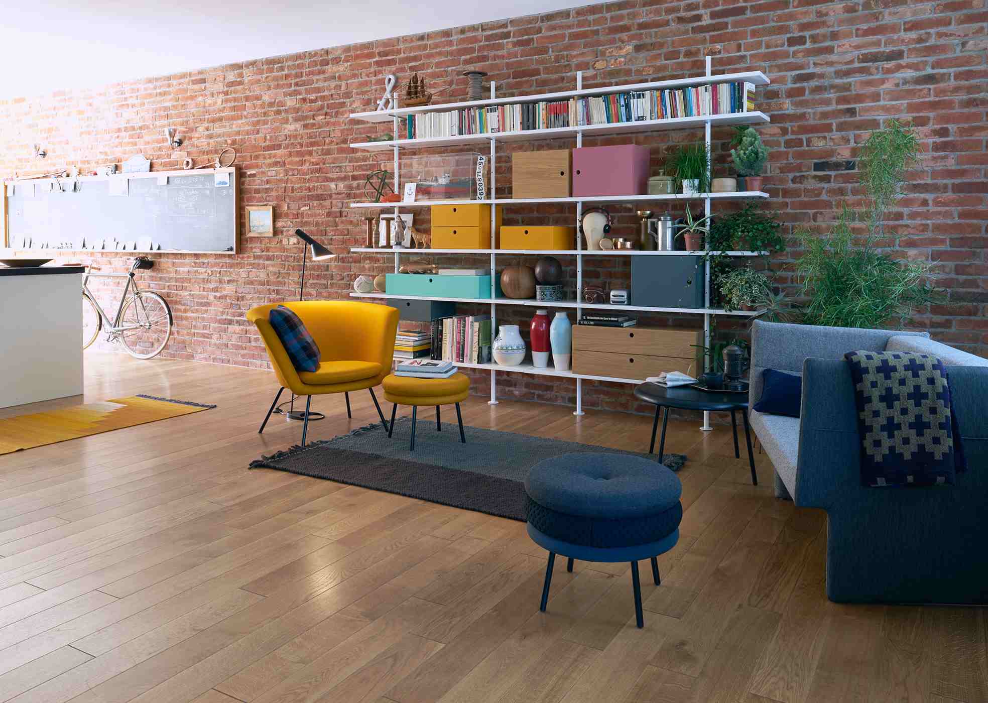 Detailaufnahme eines weißen Eiermann Regals mit einem 45 cm tiefen Zusatzboden in einem Wohnzimmer.