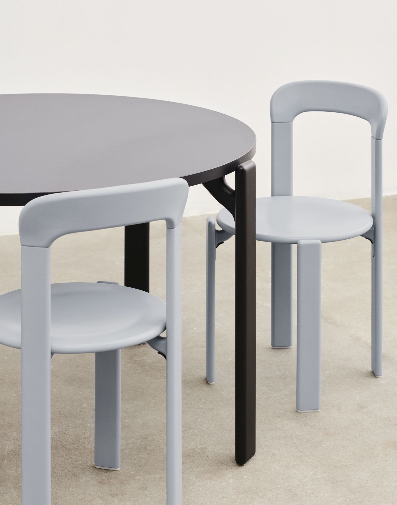 Runder Esstisch Rey Table von Hay mit zwei hellgrauen Stühlen im minimalistischen Design.
