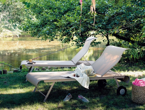 Dune Sonnenliege von Fermob im Freien am See, ideal zum Entspannen und Sonnenbaden.