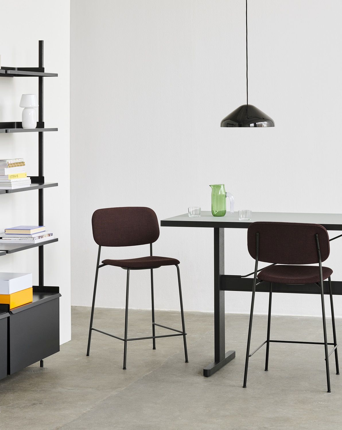 Zwei braune Hay Soft Edge Barhocker mit schwarzem Gestell an einem Tisch. Design Barstuhl.