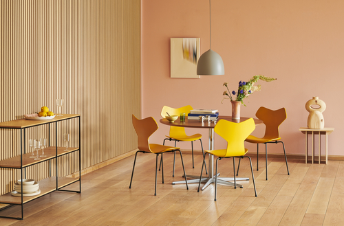 Helles Esszimmer mit Fritz Hansen Planner Shelving Regal, Tisch, Stühlen und Dekoration.