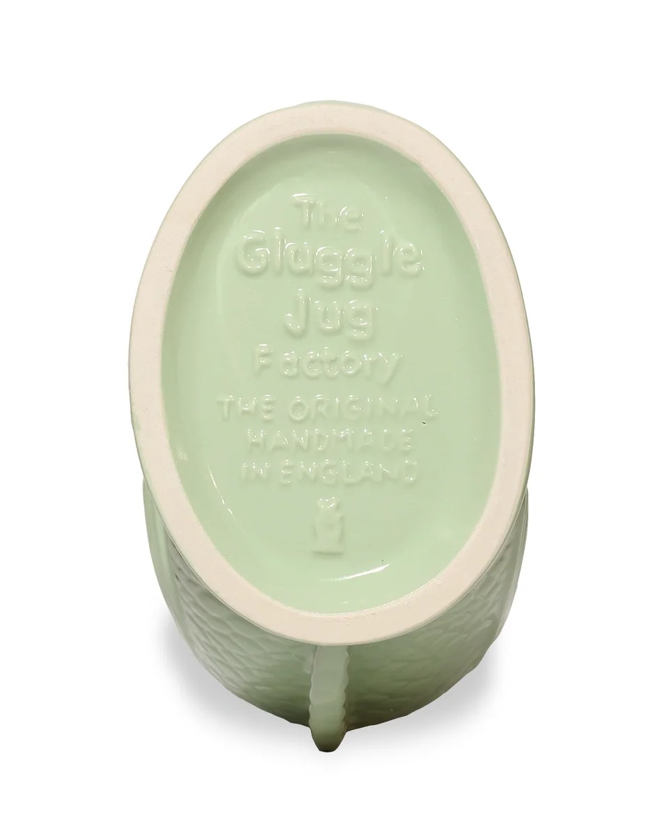 Detailaufnahme des Bodens einer hellgrünen Gluckigluck Karaffe. Keramikvase mit Herstelleraufdruck "The Gluggle Jug Factory".