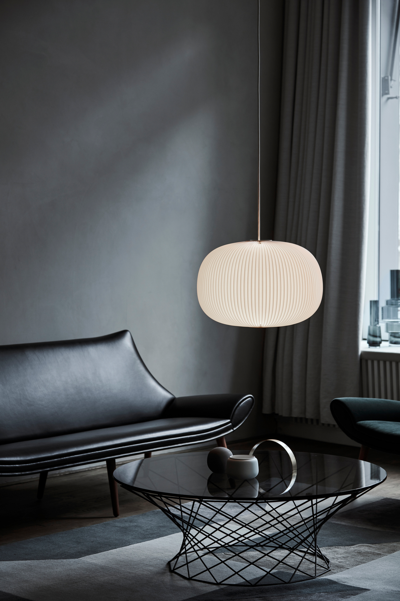 Lamella Pendelleuchte von Le Klint, cremefarben, in modernem Wohnzimmer mit Sofa und Tisch.