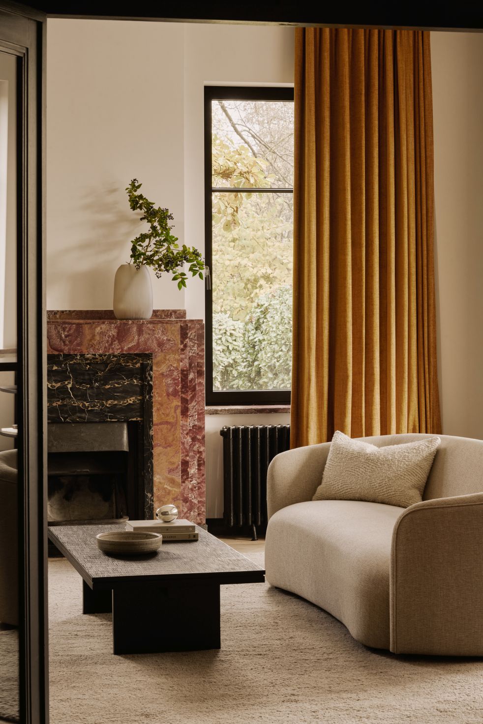 Grooves Couchtisch von Ethnicraft im Wohnzimmer mit Kamin und beigem Sofa. Moderner Holztisch.