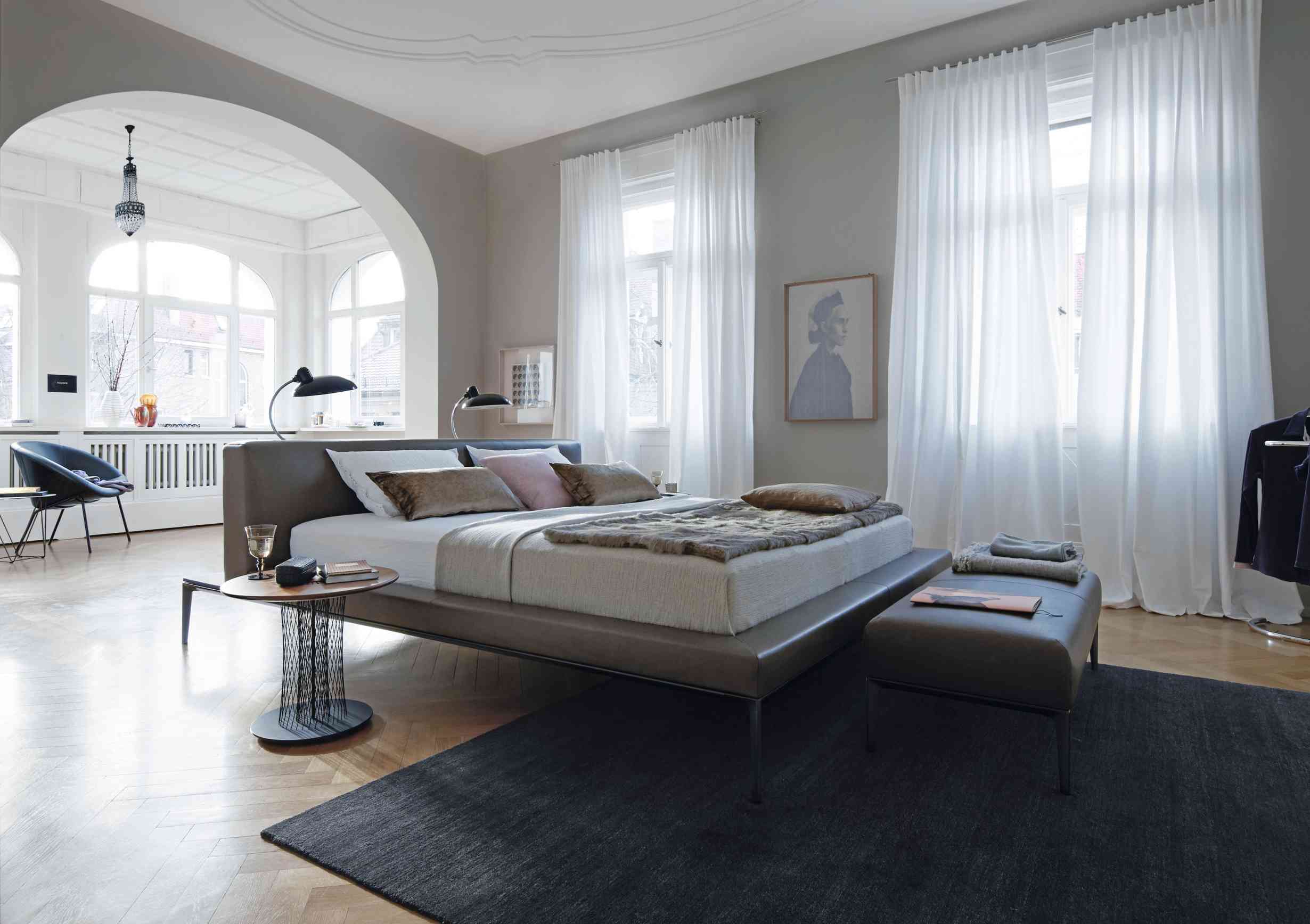 Jaan Bett von Walter Knoll: Elegantes Schlafzimmer mit modernem Lederbett, Nachttisch und Tagesdecke.