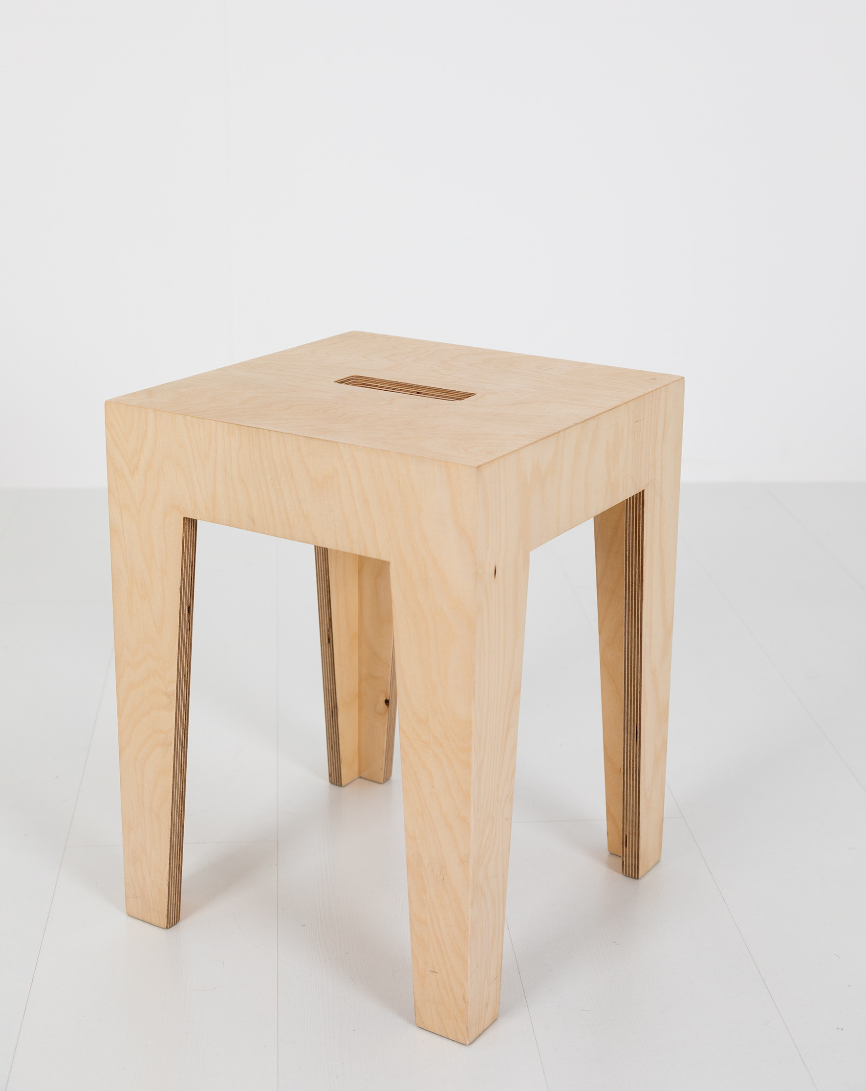 HENRIK Hocker aus hellem Holz, quadratisch mit Schlitz im Sitz, minimalistisches Design.