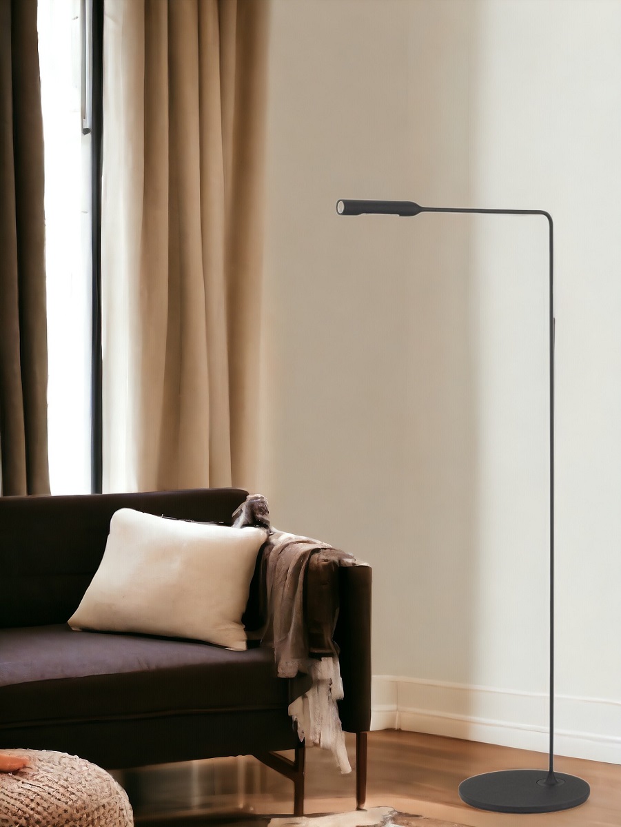 Schwarze Flo Floor Stehleuchte von Lumina neben einem Sofa in einem Wohnzimmer.