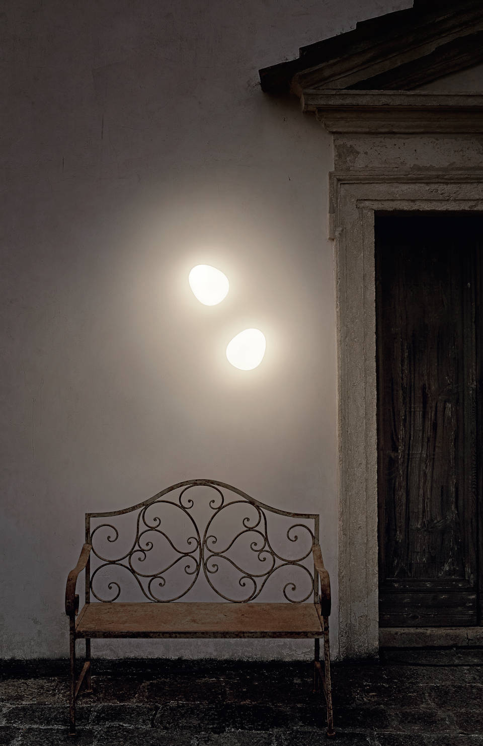 Zwei Gregg Leuchten von Foscarini an einer Wand über einer Bank.