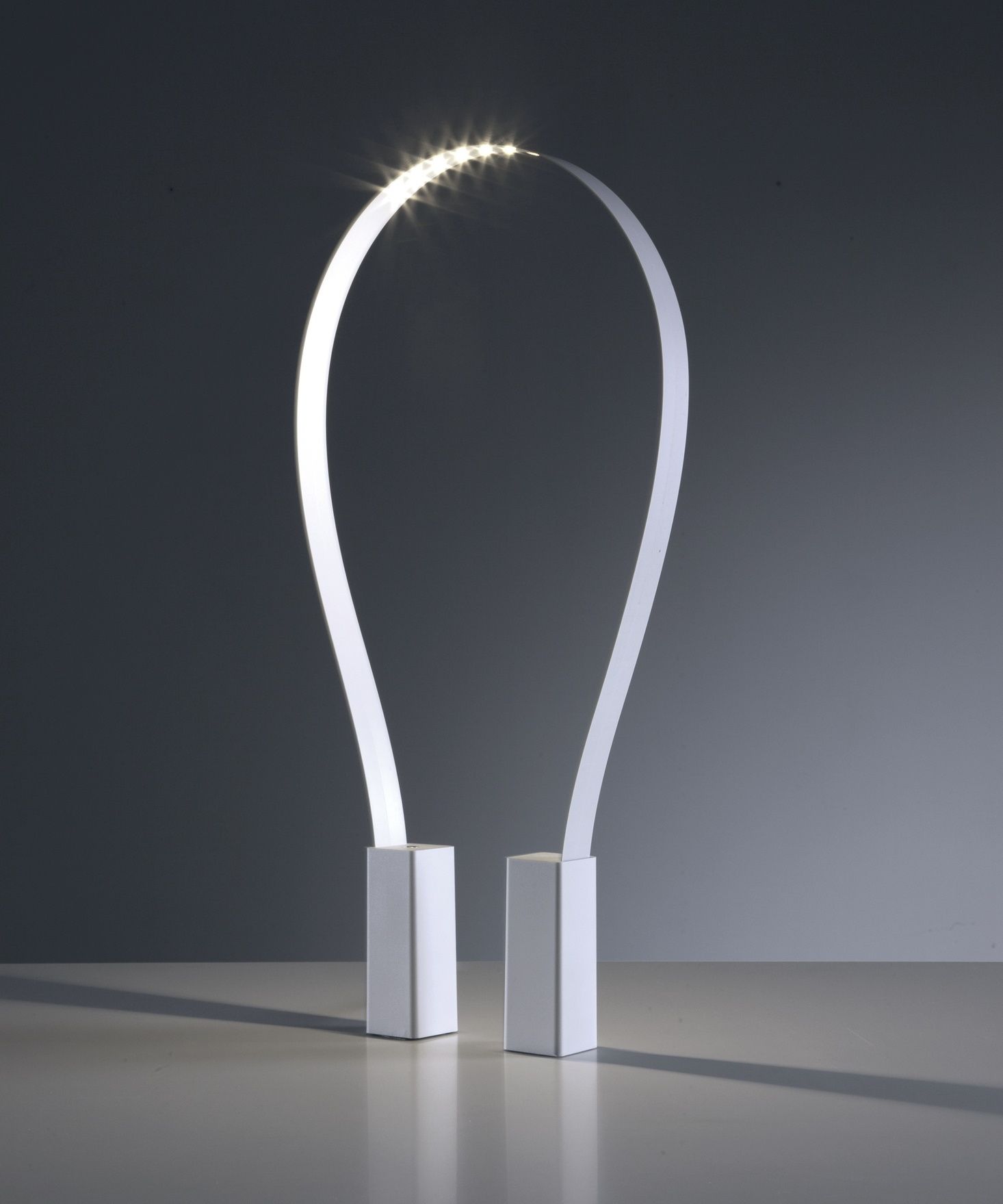 Fluida Tischleuchte von Martinelli Luce: Moderne LED-Tischlampe in Weiß mit gebogenem Design.