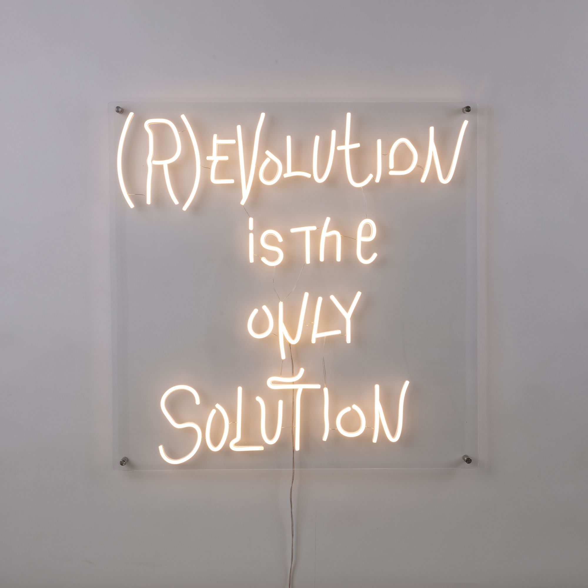 Revolution LED Wandleuchte Seletti: Neon-Schriftzug "(R)EVOLUTION is the ONLY SOLUTION" an der Wand.