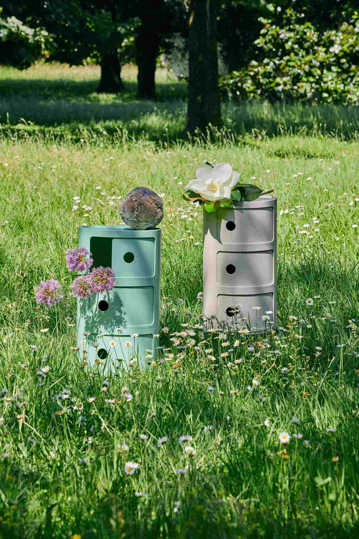 Componibili BIO 3er Element Kartell Creme und Grün im Gras mit Blumen dekoriert.
