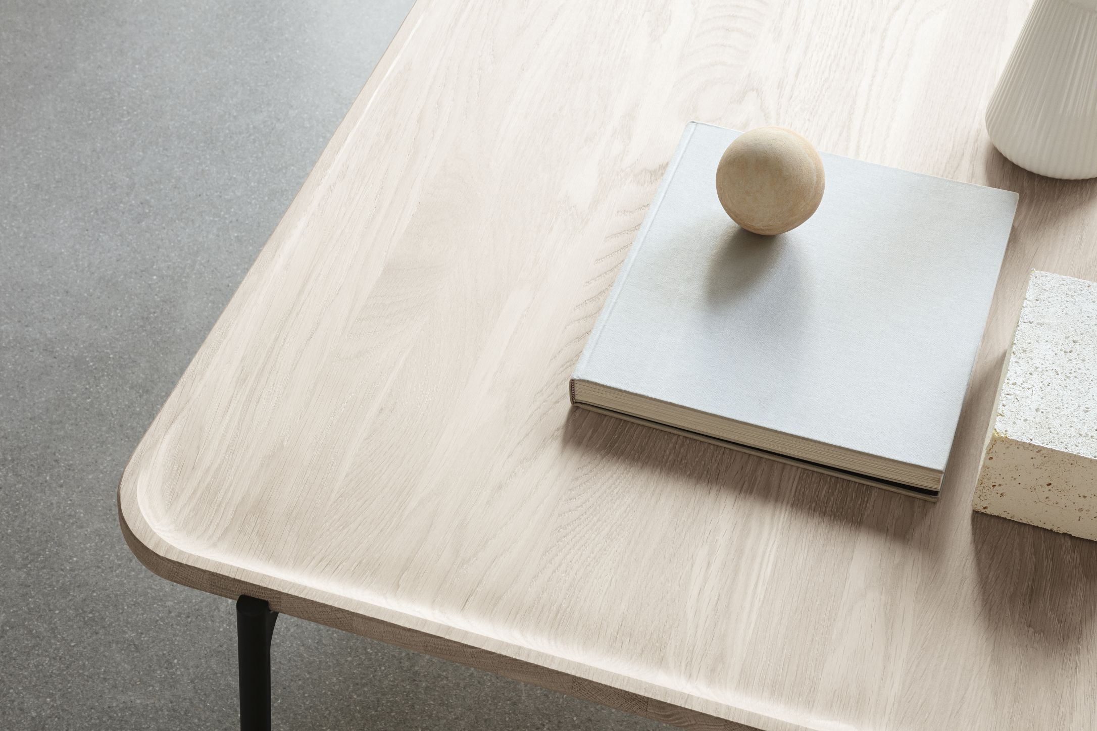 Detailansicht des Savoye Tisches von Eva Solo: Rechteckiger Couchtisch aus heller Eiche mit Buch und Dekoration.