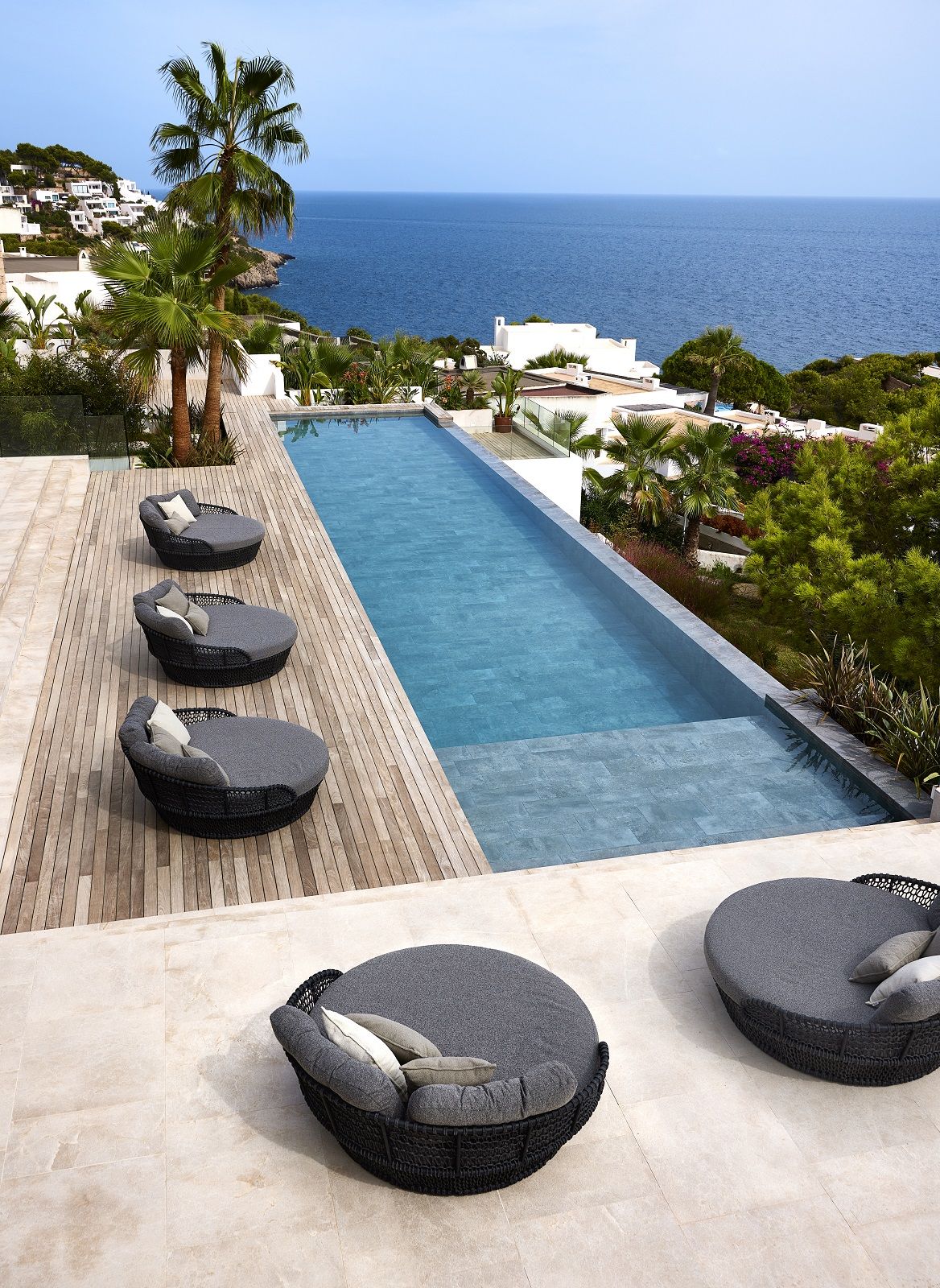 Ocean Outdoor Daybeds in Dunkelgrau am Pool mit Meerblick, moderne Gartenmöbel aus Rattan.