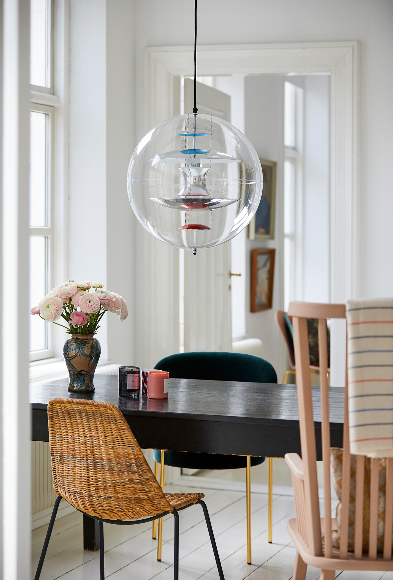 VP Globe Pendelleuchte von Verpan über Esstisch mit Stühlen und Blumenvase in hellem Raum.