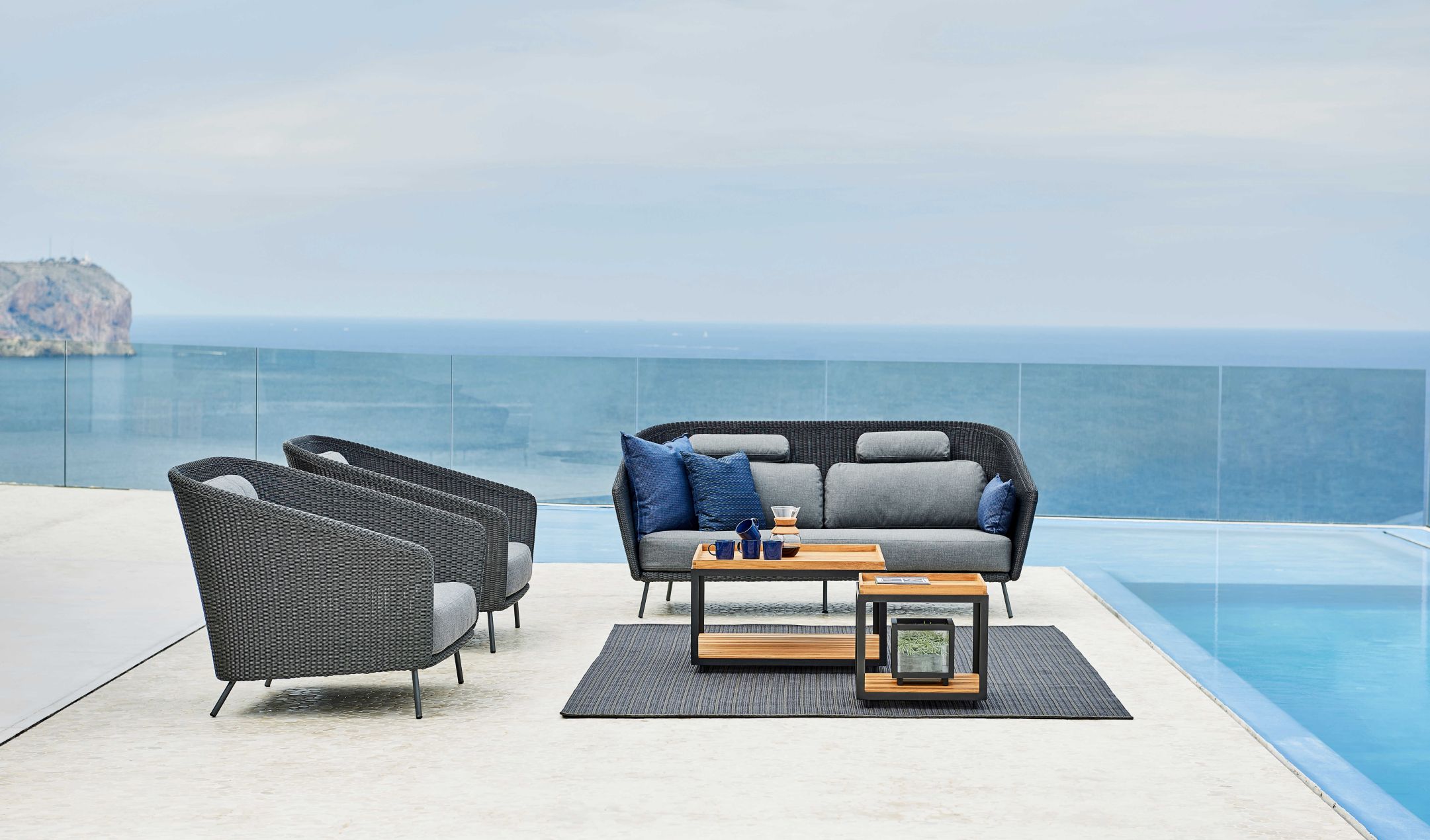 Mega Outdoor Loungesessel von Cane-Line aus Rattan mit grauen Polstern und passendem Outdoor-Sofa.