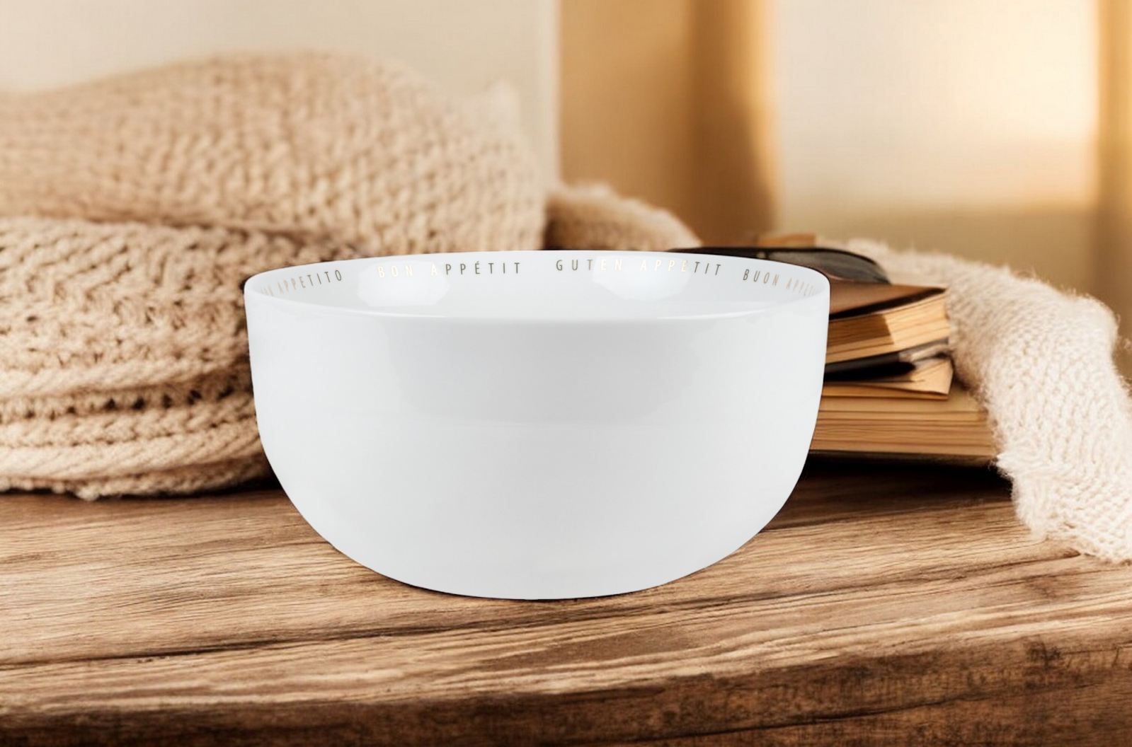 Weiße "Guten Appetit" Schüssel von Räder auf Holztisch mit Strick und Buch.