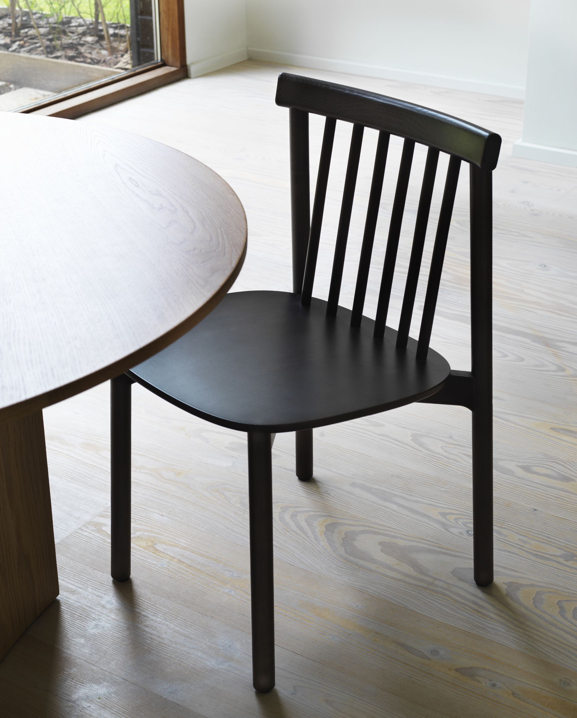 Schwarzer Pind Chair Stuhl von Normann Copenhagen aus Holz neben einem runden Tisch.