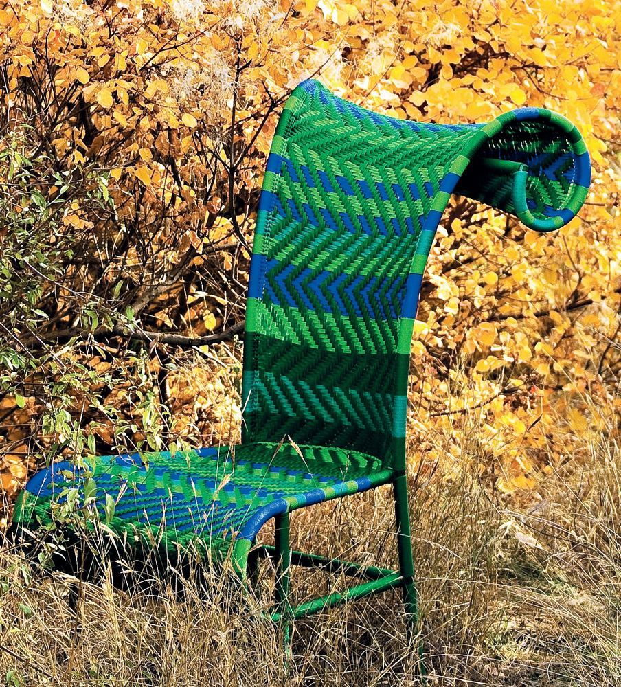 Sunny Stuhl, M' Afrique Collection, Moroso: Geflochtener Outdoor-Stuhl in Grün- und Blautönen vor herbstlichem Hintergrund.