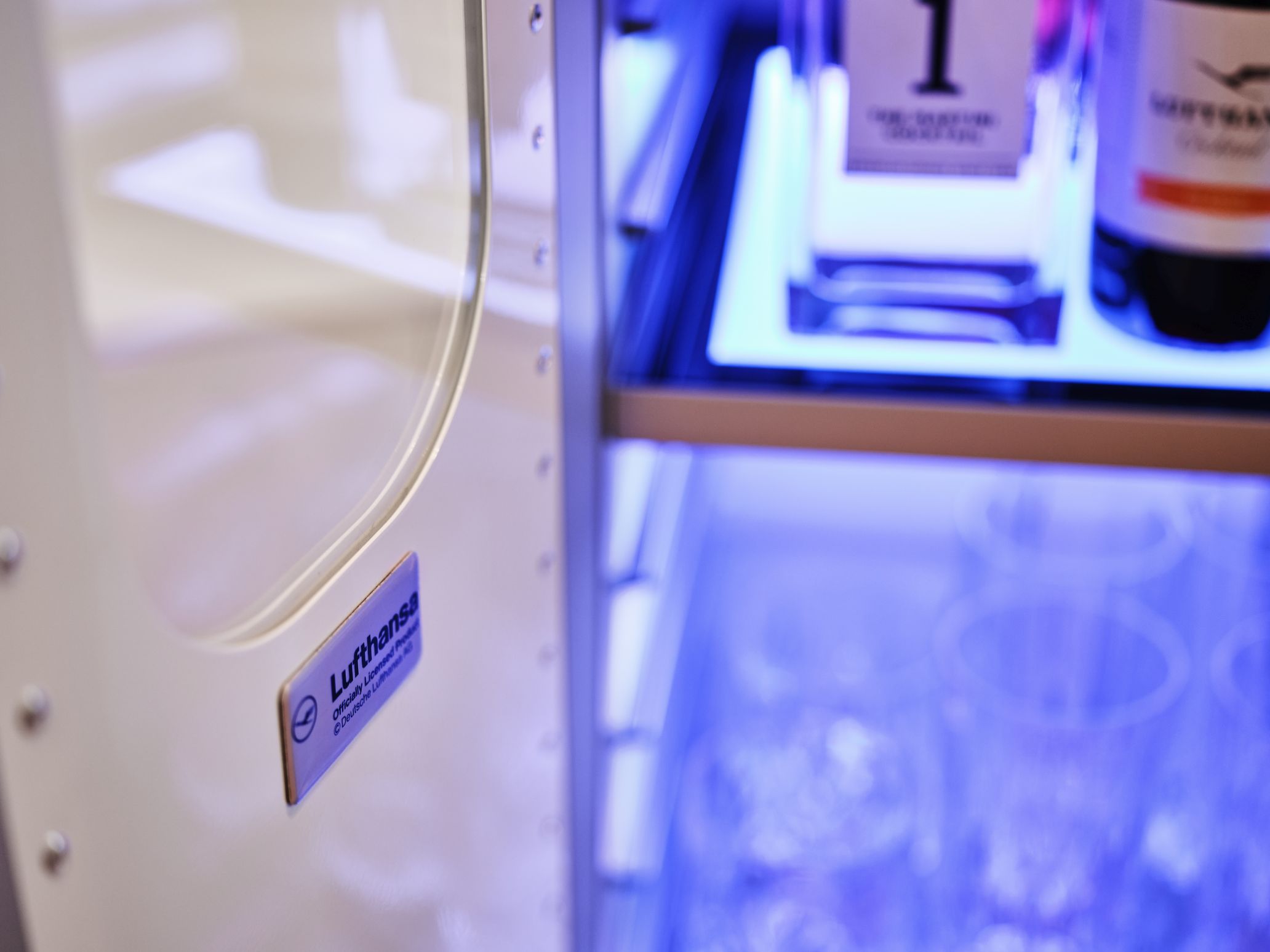 Detailaufnahme einer Bordbar mit Bar Equipment Set, inklusive Gläser und Flaschen, beleuchtet mit blauem Licht.