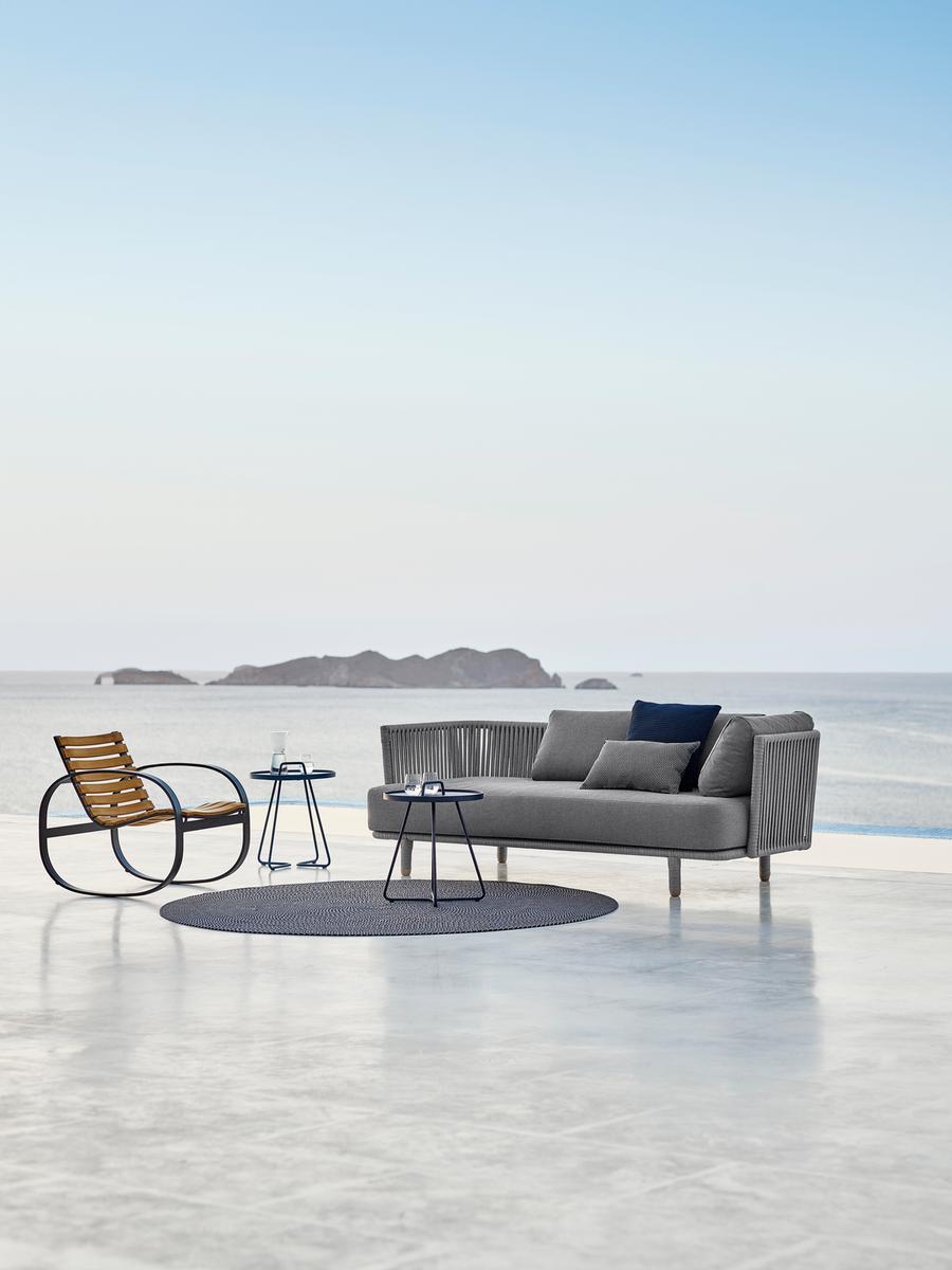 Cane-Line Moments Outdoor Sofa 3-Sitzer in Grau mit passendem Sessel und Beistelltischen.