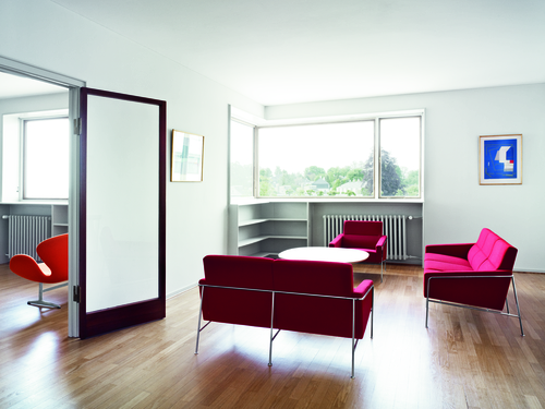 Helles Wohnzimmer mit rotem Serie 3300 Sofa und Sesseln von Fritz Hansen.