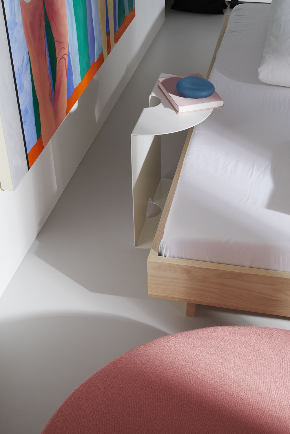 Detailaufnahme von einem ZIANS Bett Large mit Eiche-Rahmen, weißer Bettwäsche und Nachttisch.