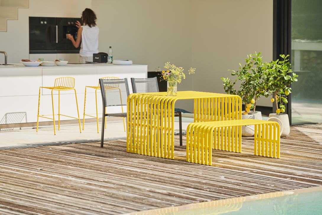 Gelber Jan Kurtz Campus Tisch mit Bank und Stühlen für den Outdoor-Bereich.