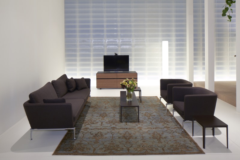 Wohnzimmer mit braunem Suita Club Sessel, Sofa, Teppich und TV-Möbeln in minimalistischem Design.