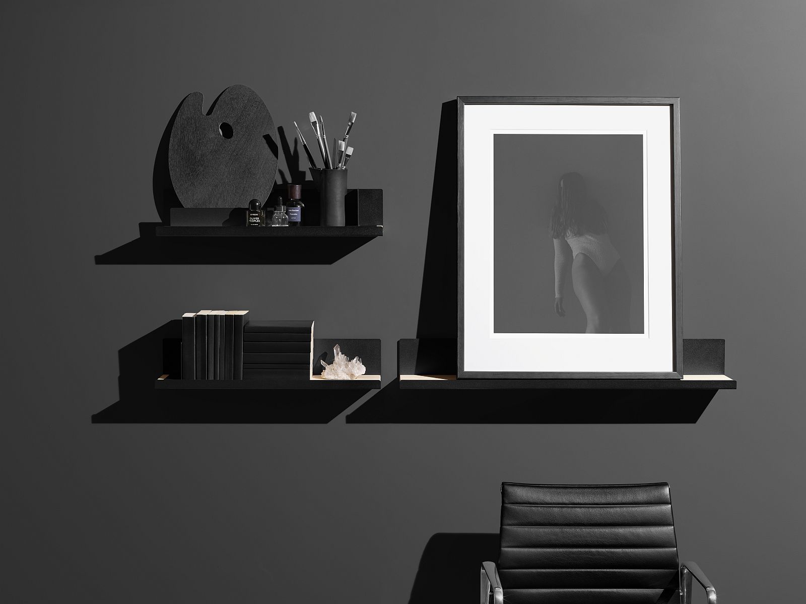 Schwarzes Edit Shelf Regal von Mizetto mit Kunstobjekten und Büchern an dunkler Wand.