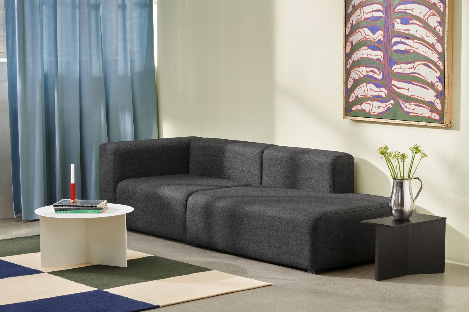 Weißer Slit Table Round XL Beistelltisch von Hay neben einem grauen Sofa in einem Wohnzimmer.