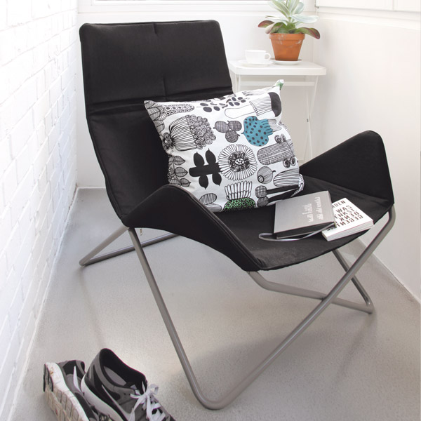 Schwarzer In-Out Sessel von Richard Lampert mit Kissen und Büchern, Indoor-Nutzung. Bequemer Design-Sessel.