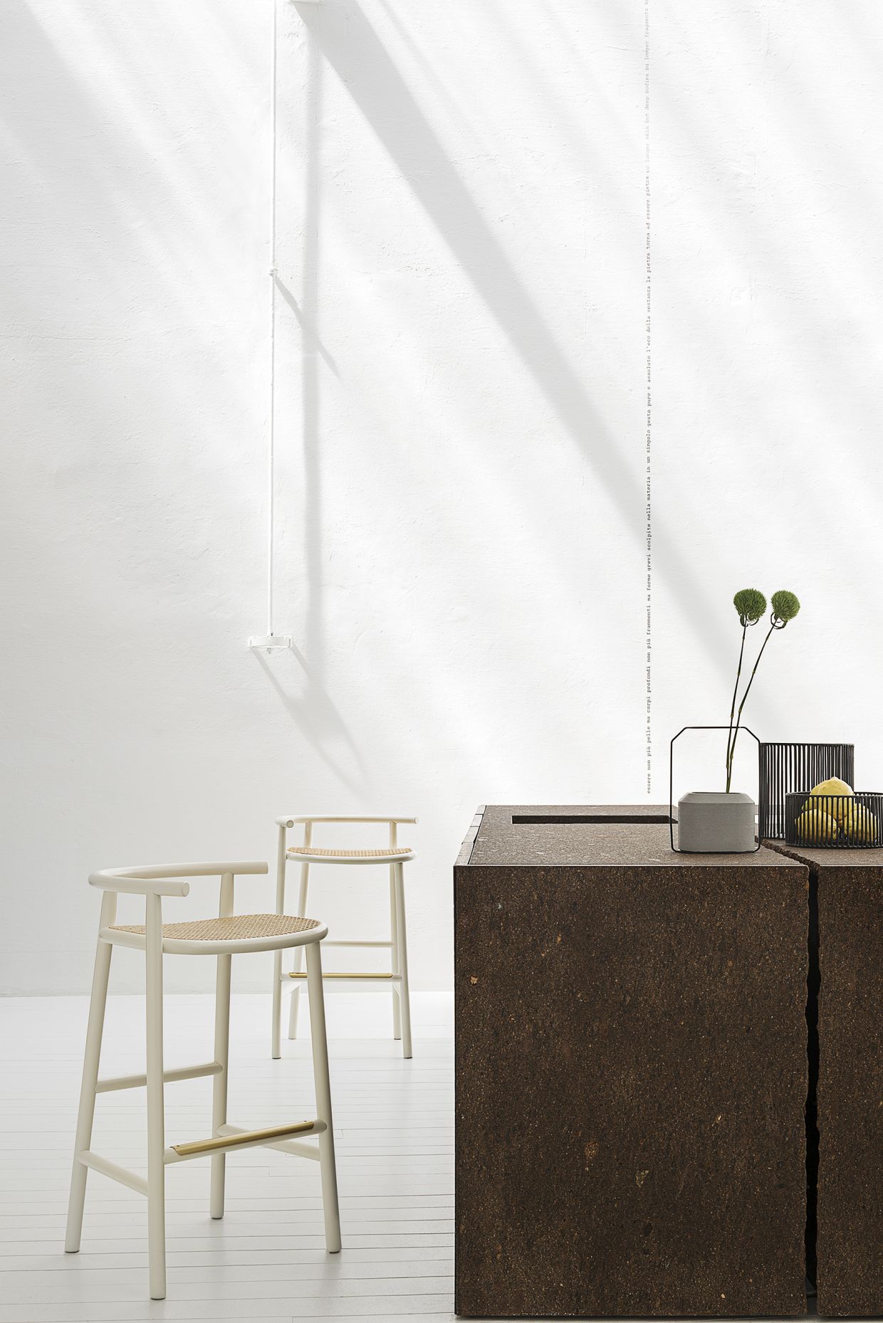 Zwei weiße Barhocker mit geflochtenen Sitzen von Wiener GTV Design vor minimalistischem Hintergrund.