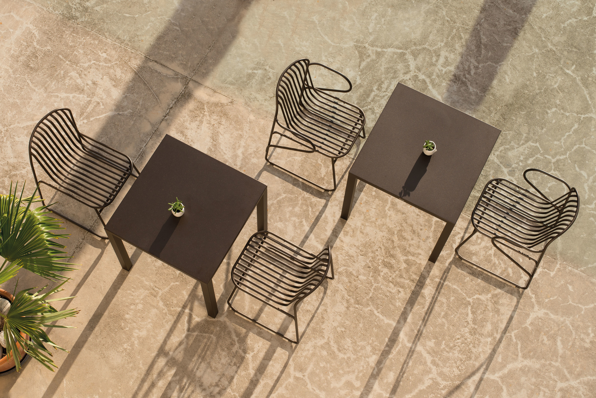 Draufsicht: Riviera Stuhl von Emu mit Metallgestell und passenden Gartentischen auf Terrasse.