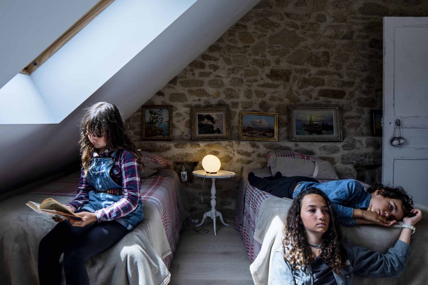 Zwei Kinder in einem Zimmer, beleuchtet von einer Gregg Tischleuchte von Foscarini.