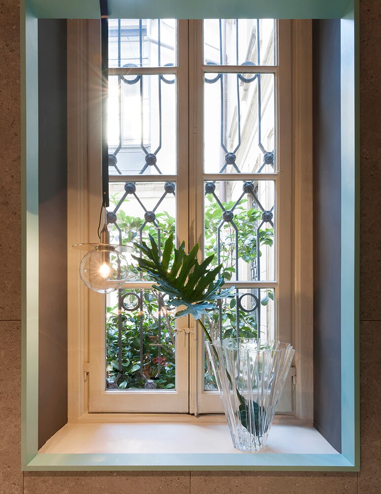 Klare Shanghai Vase von Kartell auf einer Fensterbank mit Pflanze und Dekoration.