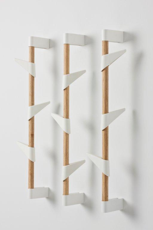 Drei Cascando Wandgarderoben aus Bambus mit weißen Haken an einer weißen Wand.