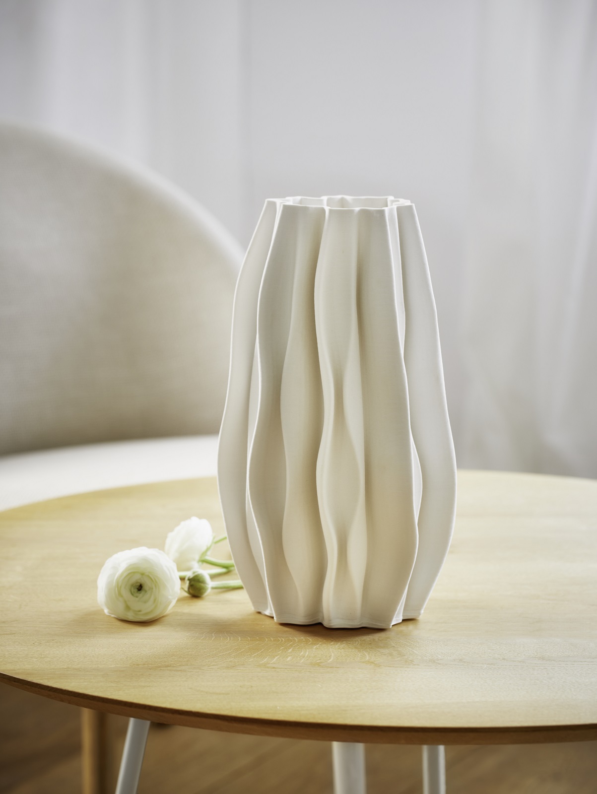 Weiße PLISSEE Vase von Philippi aus Keramik mit Blumen auf einem Holztisch.