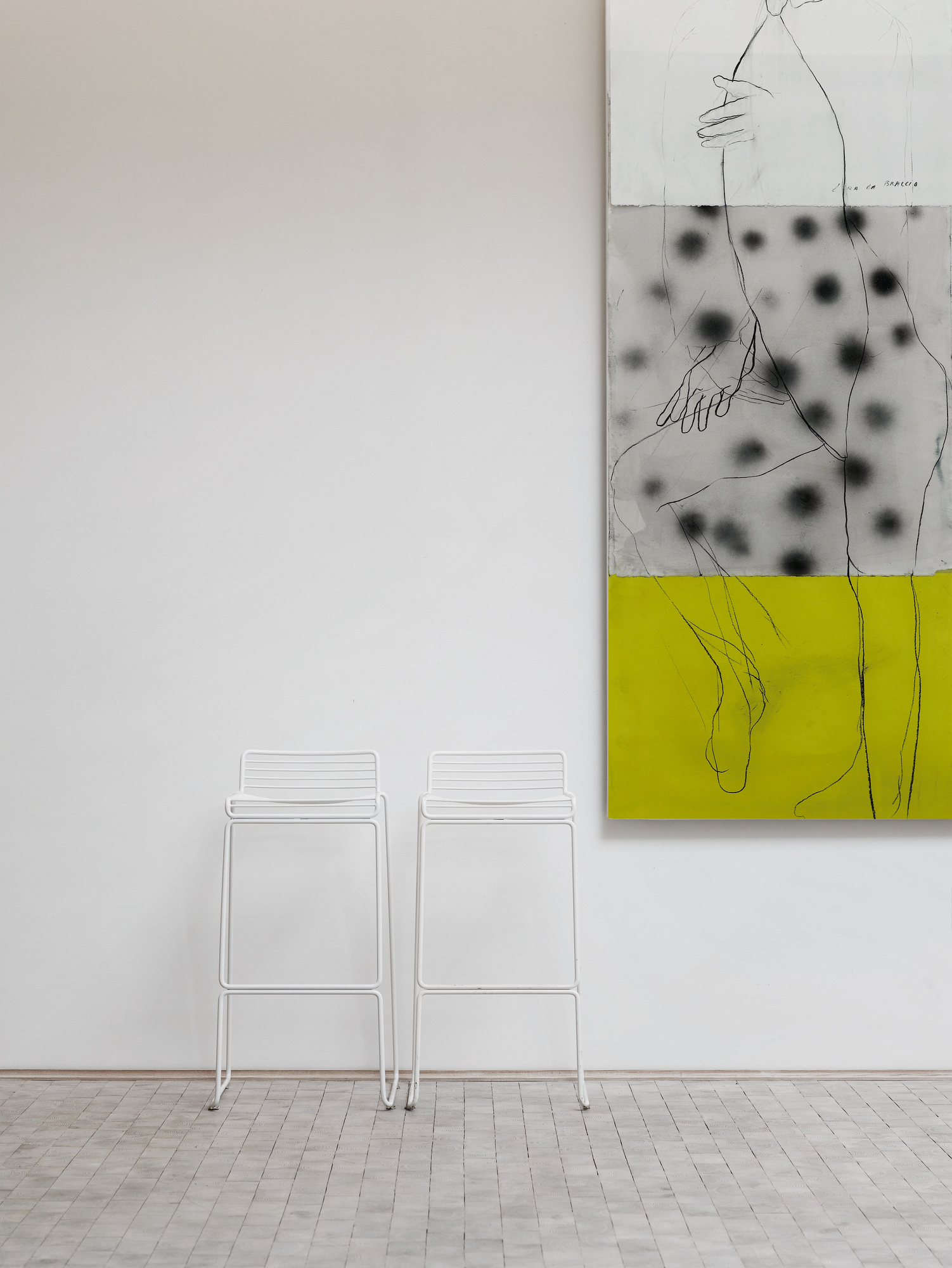 Zwei weiße Hee Barhocker von Hay vor einer weißen Wand mit Kunstwerk.