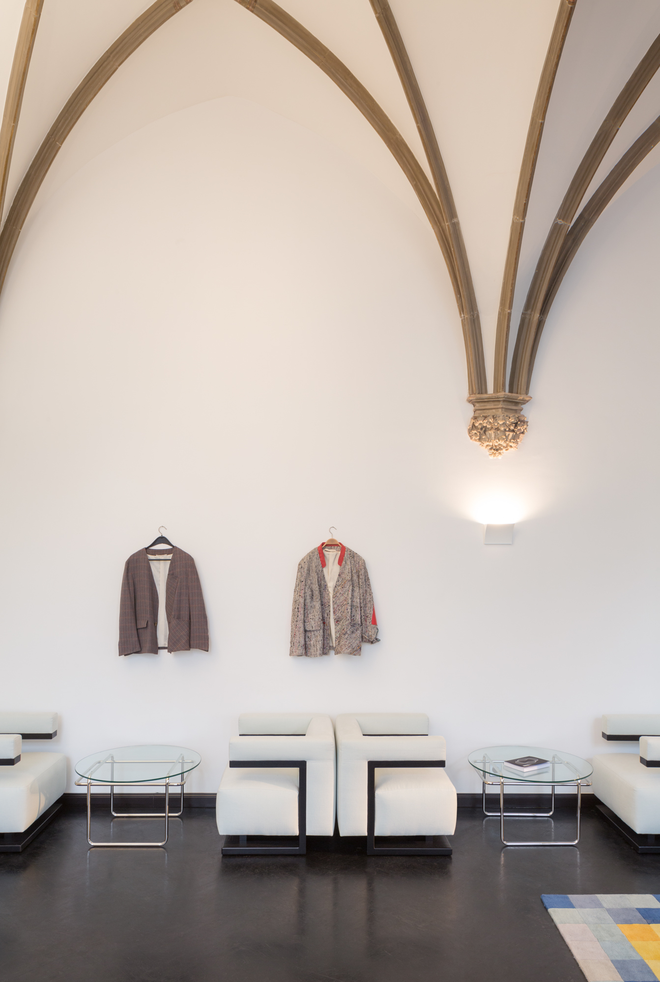 Interieur mit weißen Bauhaus Sesseln und Glas-Couchtischen vor einer weißen Wand.