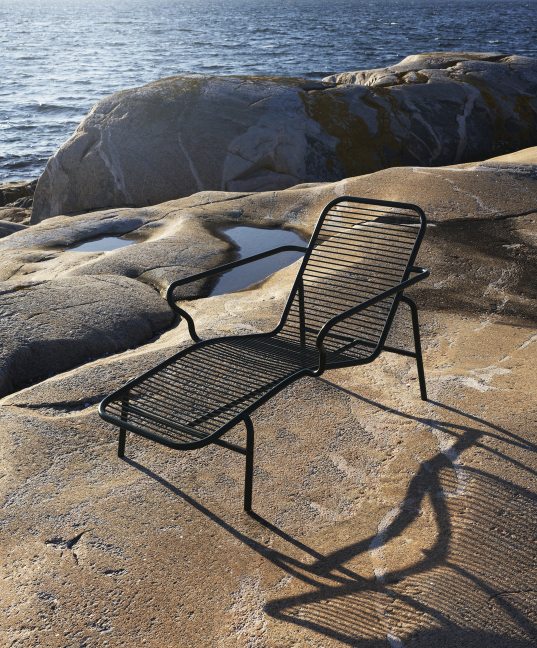 Normann Copenhagen Vig Chaise Longue Outdoor Liege auf Felsen am Meer, modernes Design für Garten und Terrasse.