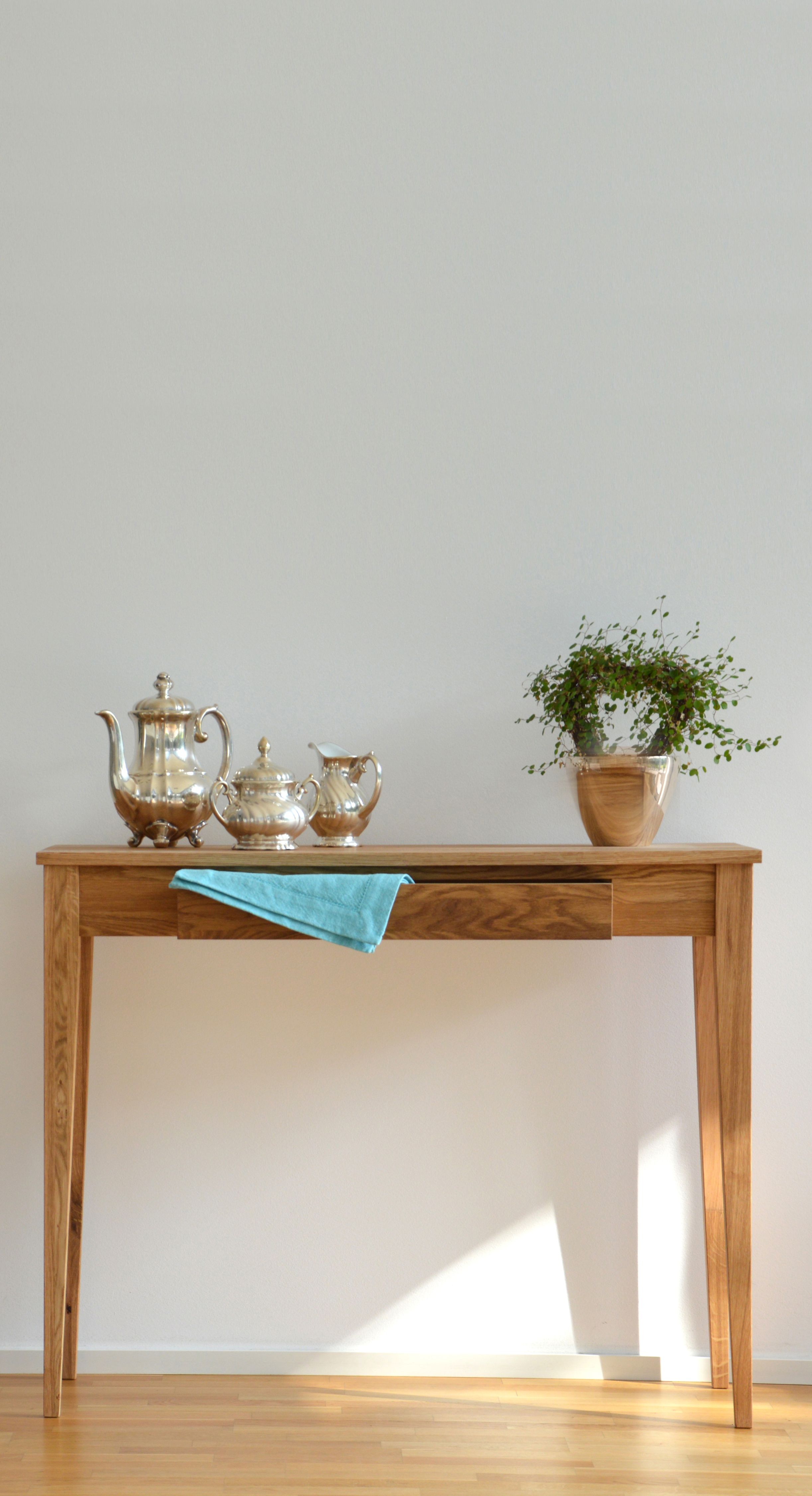 Bonny Beistelltisch von Jan Kurtz aus hellem Holz mit Schublade, Teegeschirr und Pflanze.