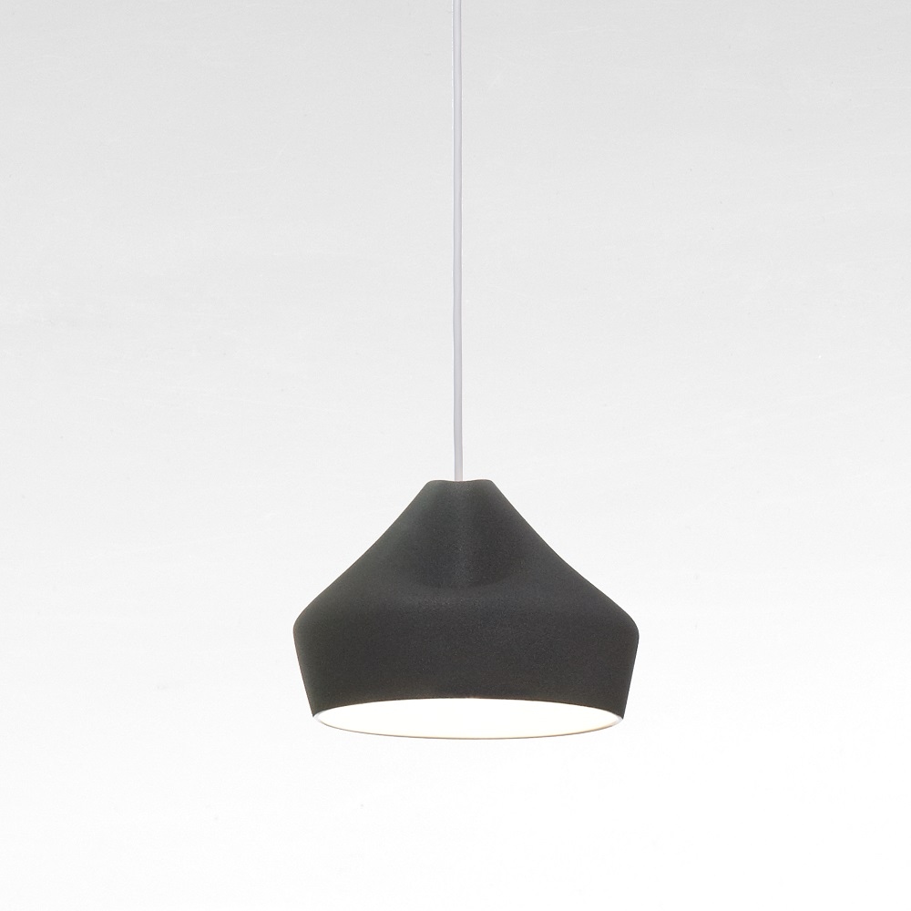 Schwarze Pleat Box Pendelleuchte von Marset mit plissiertem Lampenschirm und warmem Lichtschein.