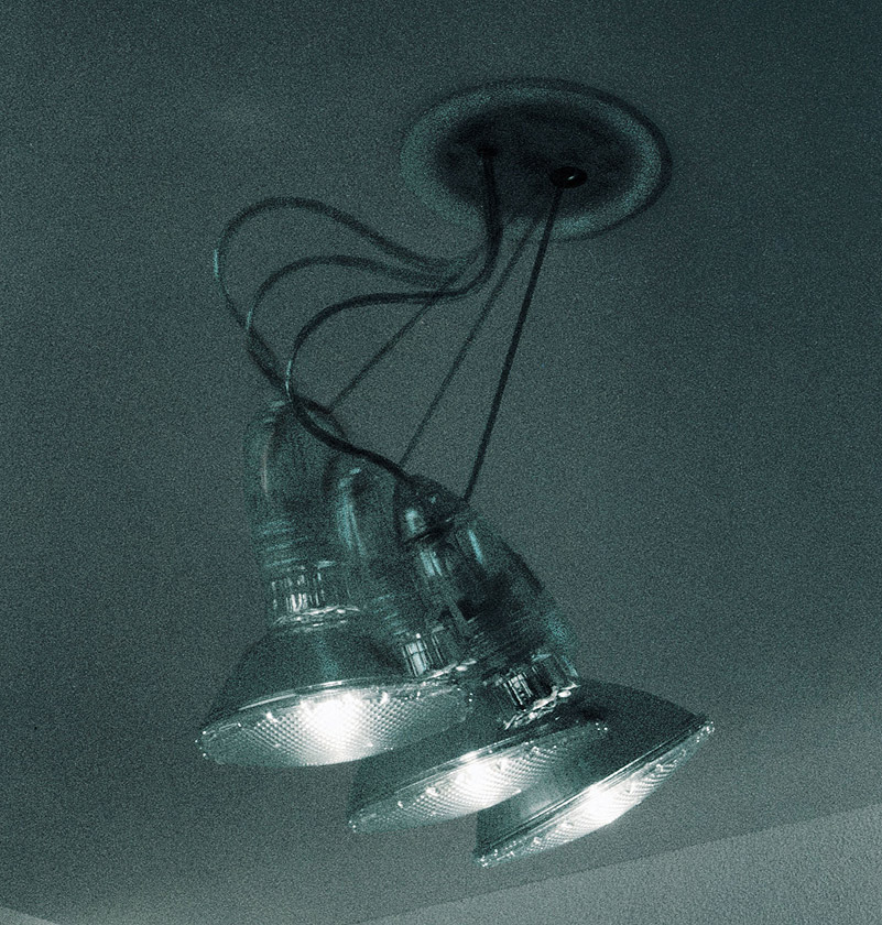 Nahaufnahme der Spock Deckenleuchte von Ingo Maurer mit drei strahlenden Lampen.