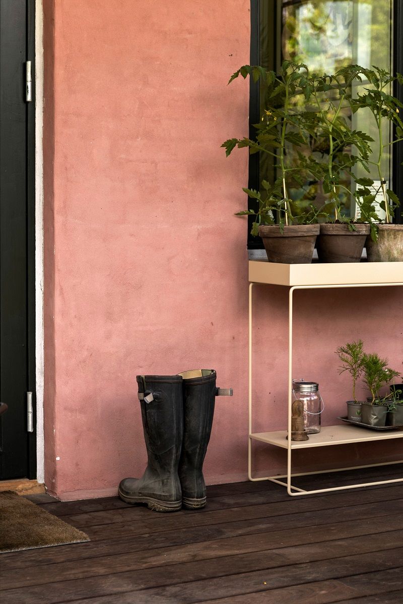 Ferm Living Plant Box Two-Tier: Pflanzenständer mit Pflanzen und Gummistiefeln auf der Terrasse.